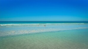 A beach with clear turquoise water and a sandy shore. - Sunset Terrace 203  - Anna Maria Island - Beach front condo 2 Bedroom/ 2 Bath Bradenton Beach, Anna Maria Island, maximum occupancy of 4 people. (Bradenton Beach)