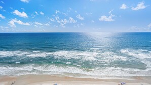 Une plage avec un ciel dégagé et des vagues calmes.