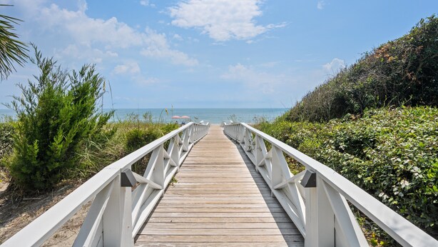 A wooden boardwalk leading to a beach with white railings and lush greenery on both sides. - Screened porches, decks, rockers, hammocks and an upstairs balcony with ocean views (Boquete)