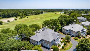 A residential area with houses, a golf course, and a lake.