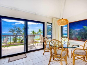 Enjoy ocean views from the balcony, featuring a round table and wicker chairs.