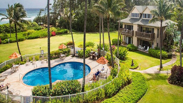 A resort with a swimming pool, outdoor seating, and a view of the ocean. - Stylish Tropical Suite w/Bath+Kitchen Upgrades, WiFi, DVD, Lanai–Kaha Lani 113 (LIHUE)