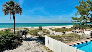 Una propiedad frente a la playa con piscina, una playa de arena y vista despejada al océano.