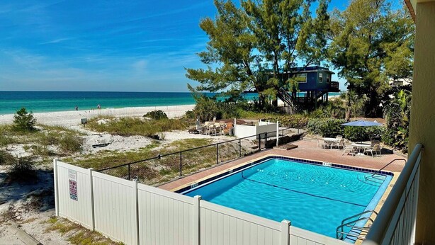 A swimming pool with a view of the beach and ocean.