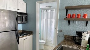 A compact kitchen with a refrigerator, microwave, and coffee maker.