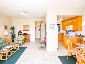 Relax in this open-plan living space with a sofa, dining table, and kitchen area featuring a microwave.