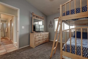 A bedroom with a bunk bed, a dresser, a television, and a mirror. - Las Palmas Resort #1018 | All-Inclusive Amenities (Saint George)