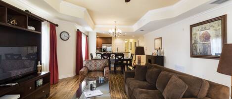 A living room with a television, sofa, and dining area.
