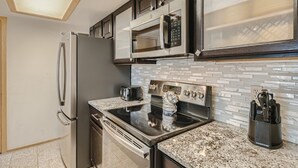 A modern kitchen with stainless steel appliances, a microwave, oven, and a granite countertop. - Two Bedroom Plus Loft with Awesome Views of Lake Dillon (Frisco)