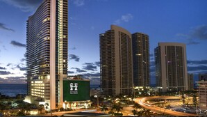 A high-rise hotel with a prominent green billboard, multiple floors, and a view of the ocean. - Perfect CornerCondo@Hyde  Ocean&WaterViews (Hollywood)