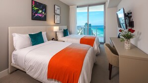 A hotel room with two beds, a desk, a chair, a TV, and a large window with a city and ocean view. - BeachFront @Hyde GreatOceanView 2BR Suite (Hollywood)