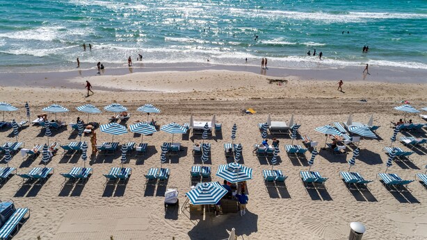 A beach with rows of sun loungers and umbrellas, a sandy beach, and the ocean in the background. - BeachFront @Hyde GreatOceanView 2BR Suite (Hollywood)