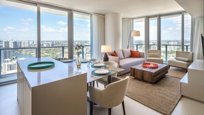 Una sala de estar moderna con comedor, ventanas amplias y vista a la ciudad.