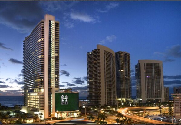A high-rise hotel with a prominent 'Hyde' sign, surrounded by other tall buildings and a busy road with palm trees. - Amazing CornerSuite, Ocean & Water Views (Hollywood)