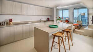 Eine moderne Küche mit einer zentralen Kochinsel, Holzstühlen und Blick auf die Stadt.