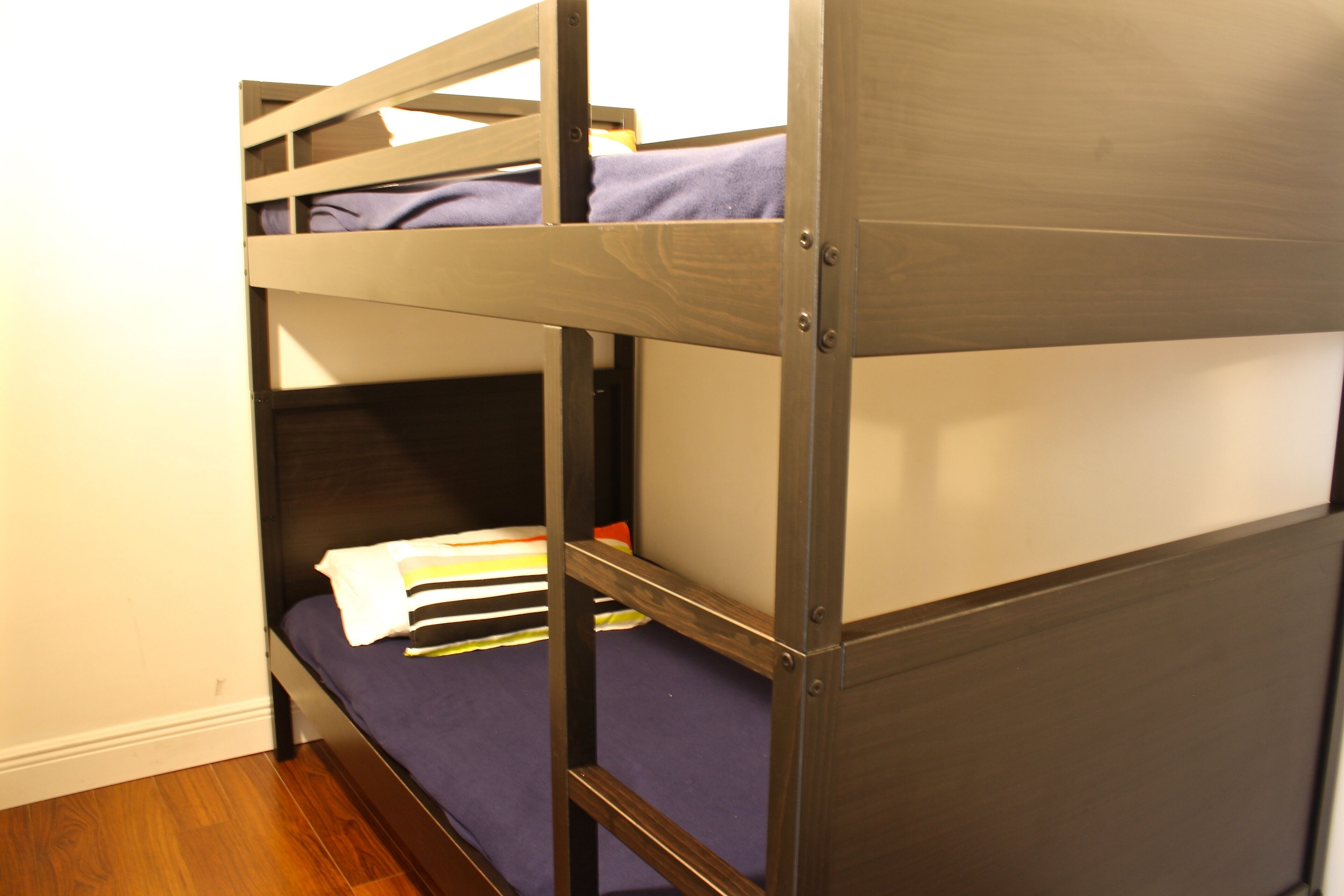 Un lit superposé avec un matelas bleu et une structure en bois.