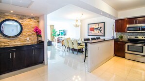 A modern kitchen with dark cabinets, a central island, and stainless steel appliances.
