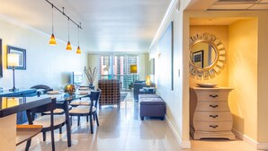 A modern hotel lobby with a dining area, a large mirror, and a staircase leading to the upper floors. - Warm condo w/ striking ocean & park views | WIFI + Parking (Sunny Isles Beach.)
