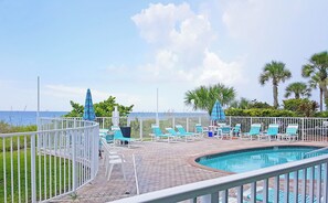 Relax by the ocean-view pool surrounded by lounge chairs and umbrellas.