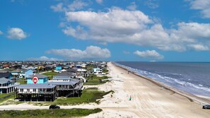 Uma área residencial costeira com casas, praia e céu claro.