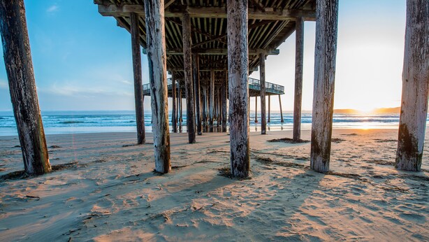 Una playa con un muelle de madera.