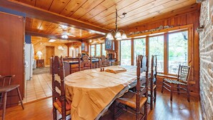 Comedor de madera con una mesa grande, sillas y un ventilador de techo.