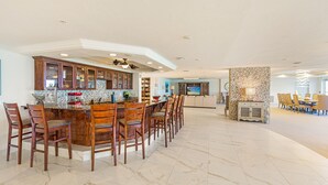 Una cocina amplia con barra, sillas de madera y una mesa de comedor.