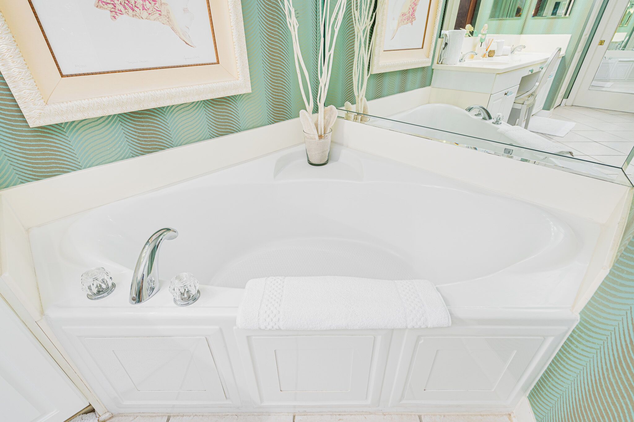 A bathroom with a large white bathtub, a glass-enclosed shower, and a mirror above the sink.