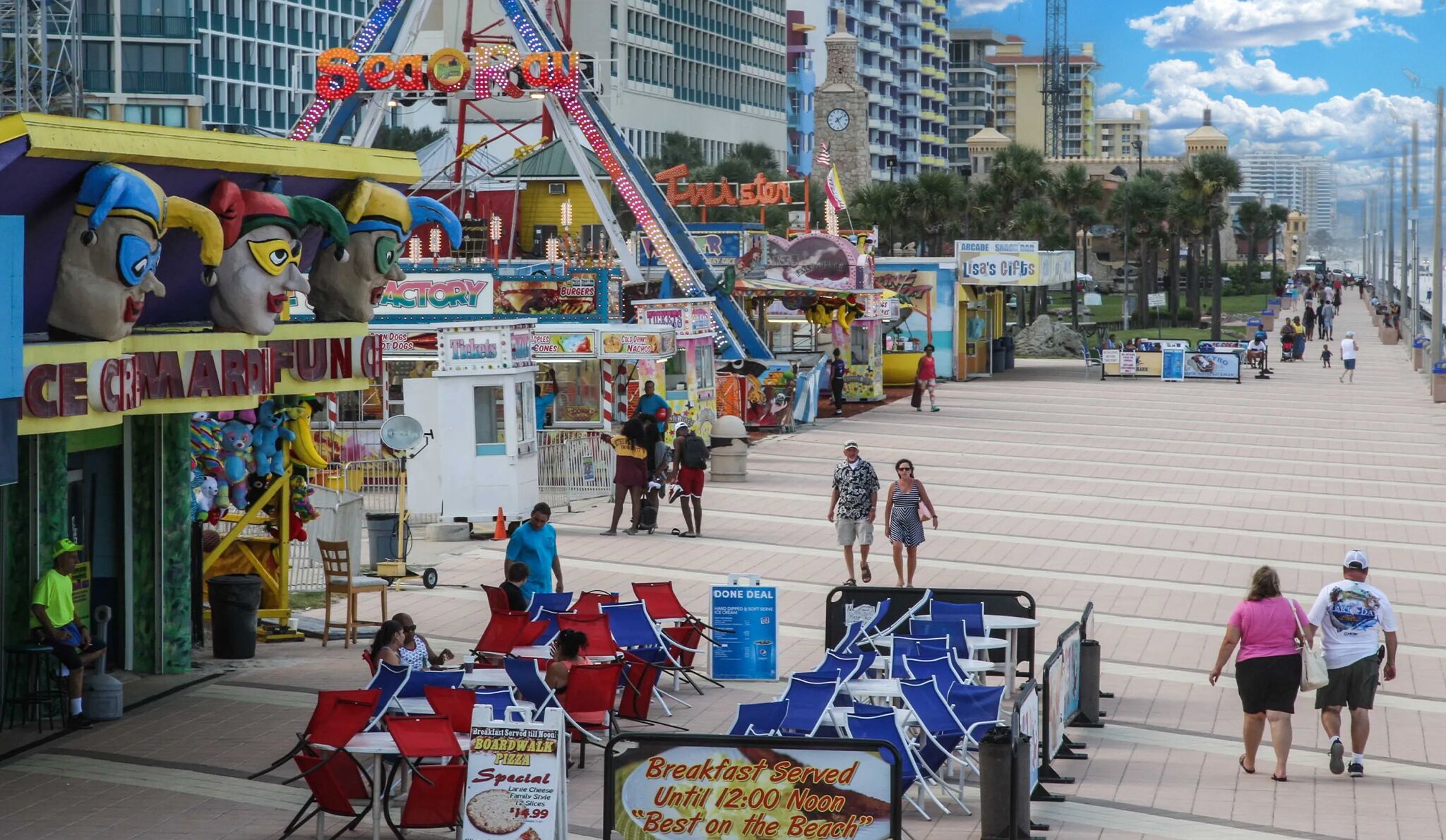 Un paseo marítimo con diversas tiendas y restaurantes, incluyendo una pizzería que sirve desayuno hasta el mediodía.