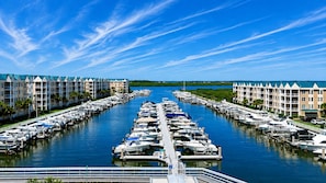 A marina with boats docked in rows, surrounded by multi-story buildings with balconies. - Harbour Village 2304 | Golf/Tennis/Pool | River View (Ponce Inlet)