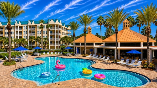 A hotel pool area with multiple lounge chairs, a swimming pool, and palm trees. - Harbour Village 2304 | Golf/Tennis/Pool | River View (Ponce Inlet)