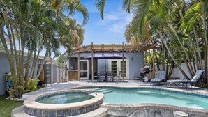 A backyard with a swimming pool, a covered patio, and lounge chairs. - Havana Cay- Adorable 3 bedroom cottage style- Pool/spa and only 4 houses from be (Anna Maria)