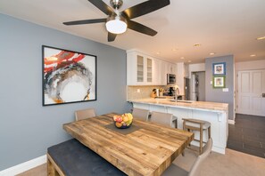 Enjoy meals in this well-equipped kitchen with a central island, sink, and microwave, and dine at the wooden table with a cushioned bench.