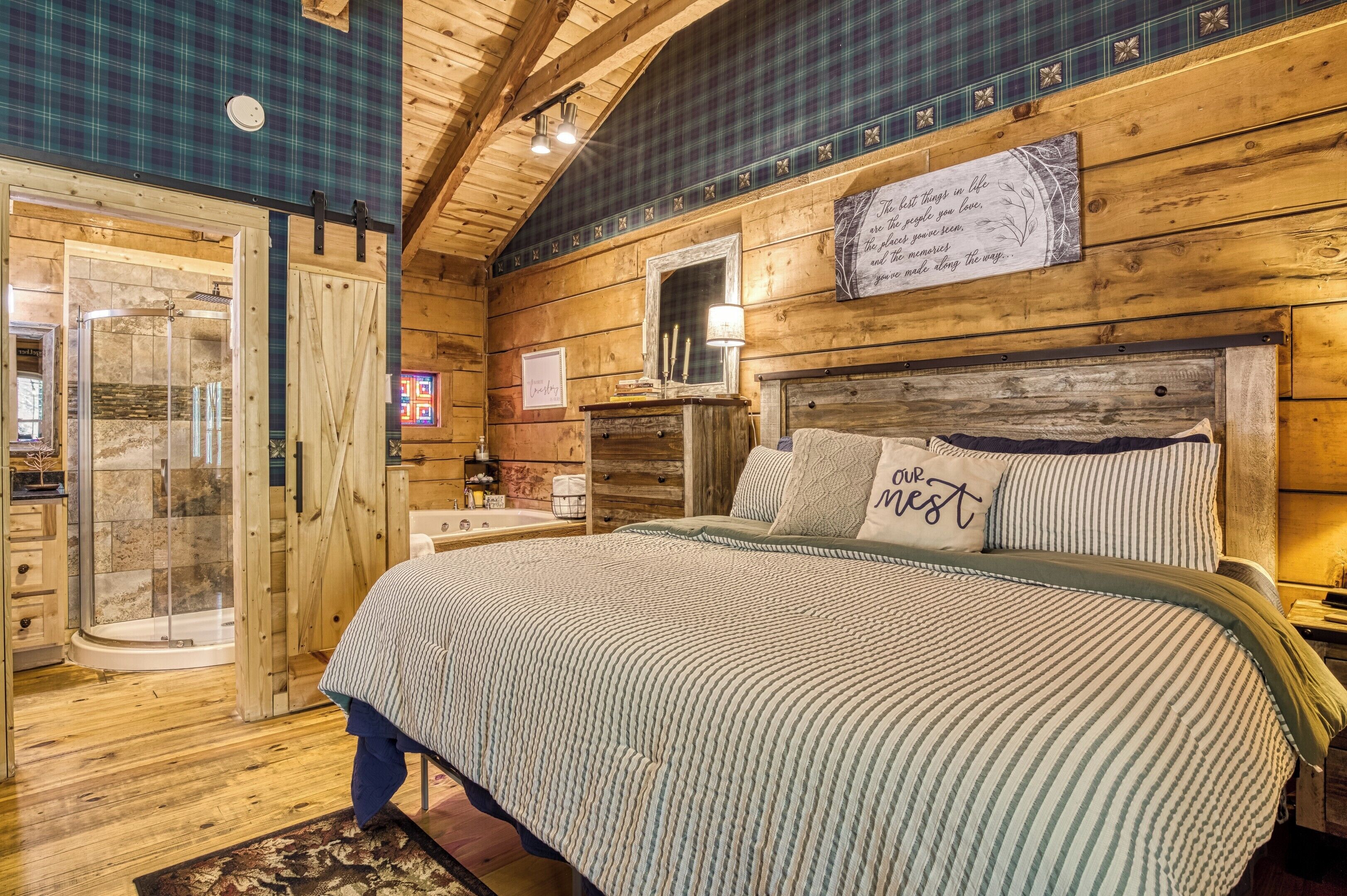 Ein Holzblockhaus-Innenraum mit einem Bett, einer Dusche und einem Schild an der Wand.