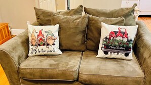 A brown sofa with two decorative pillows featuring gnome designs and holiday greetings. - 3 bdrms, Bonfire Pit, Screened Porch, Mountain Shade (Townsend)