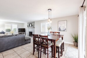 Relax in this stylish living room with a comfortable sofa, dining table, and flat-screen TV.