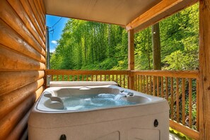 A wooden cabin with a hot tub on a deck overlooking a forest. - Hot Tub❅Wood Fireplace❅King Bed❅Cozy - BEAR'S DEN (Townsend)