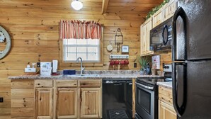 A kitchen with wooden cabinets, a refrigerator, a microwave, and a dishwasher. - Hot Tub❅Wood Fireplace❅King Bed❅Cozy - BEAR'S DEN (Townsend)