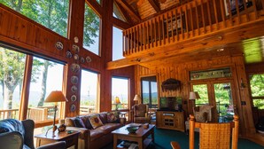 A spacious cabin with a large living area, multiple windows, and a cozy fireplace. - Mountain Cabin,180* View,HotTub,SpaTub,Pool Table,WiFi (Ferguson)
