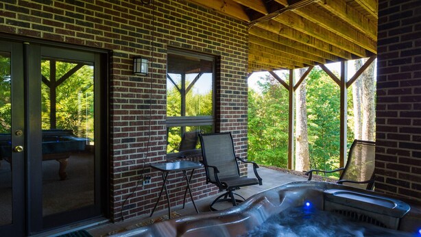 A covered outdoor area with a hot tub, two chairs, and a table. - Mountain Cabin,180* View,HotTub,SpaTub,Pool Table,WiFi (Ferguson)