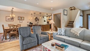 A spacious living room with a dining area, a staircase, and a kitchen in the background. - Beautiful half duplex home, recently remodeled with garage and private hot tub!! (Frisco)
