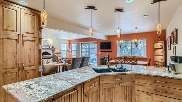 A spacious kitchen with wooden cabinets, granite countertops, and pendant lighting. - Beautiful half duplex home, recently remodeled with garage and private hot tub!! (Frisco)