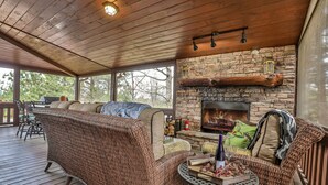 Un espace extérieur aménagé avec des meubles en osier, une cheminée en pierre et un barbecue.
