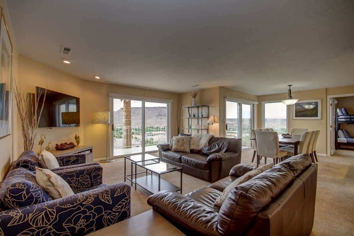 A spacious living room with a large window, a fireplace, and a dining area.