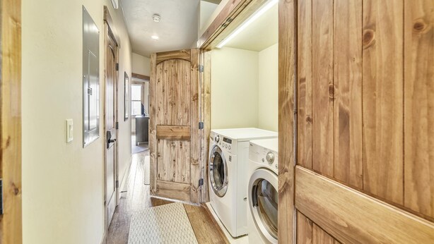 A laundry room with wooden cabinets, a washing machine, and a dryer.