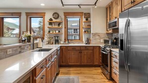 Una cocina moderna con armarios de madera, electrodomésticos de acero inoxidable y una isla grande.
