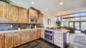 A spacious kitchen with wooden cabinets, a central island, and a dining area with a view. - Beautiful, modern condo in Marina Park in Frisco. 3 bedrooms, large, open kitchen and private 2 car garage. (Frisco)