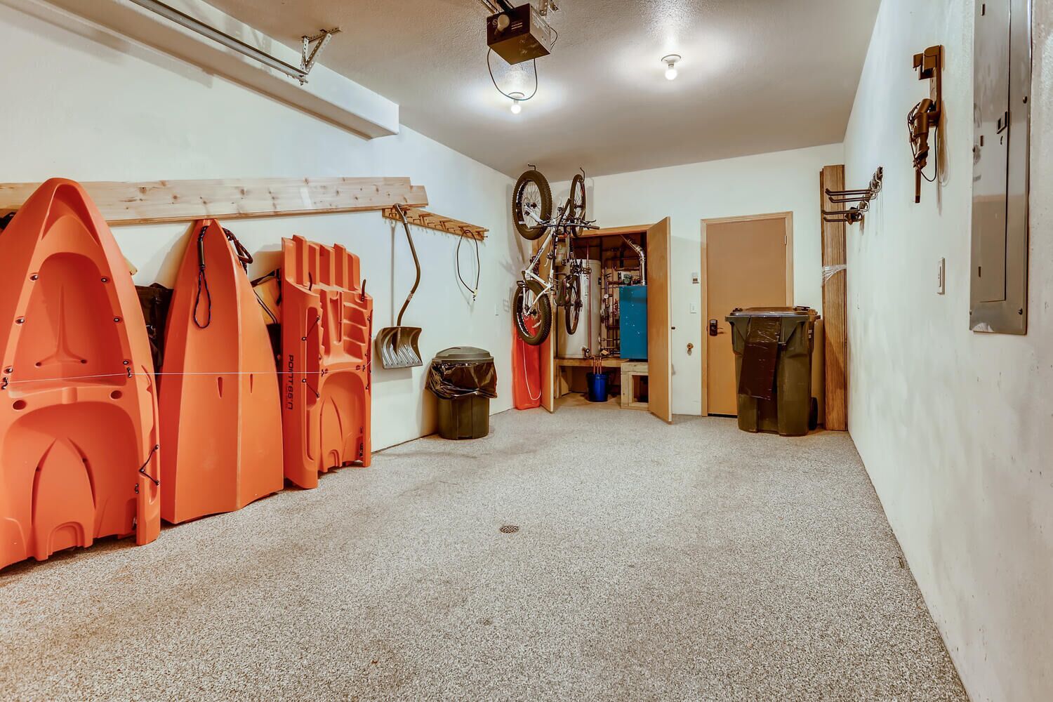 Un garage contenant des vélos, un établi et des armoires de rangement.