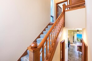 Una escalera con barandillas de madera y una alfombra azul.