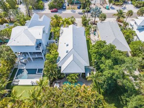 Zona residencial con casas modernas, piscina y abundante vegetación.